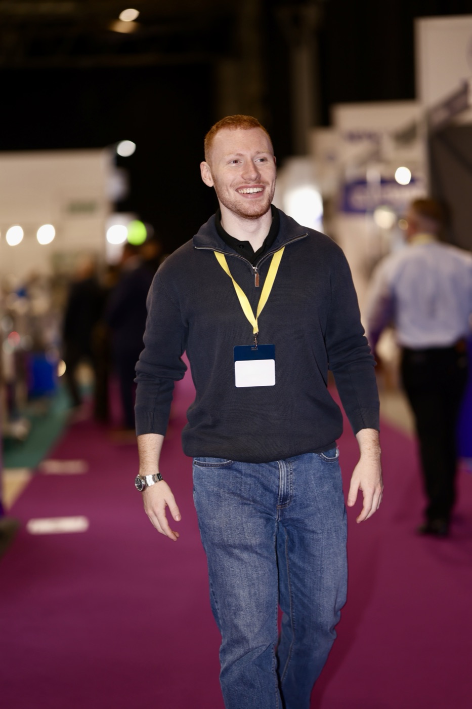 Joseph Carey walking the expo floor with a lanyard on