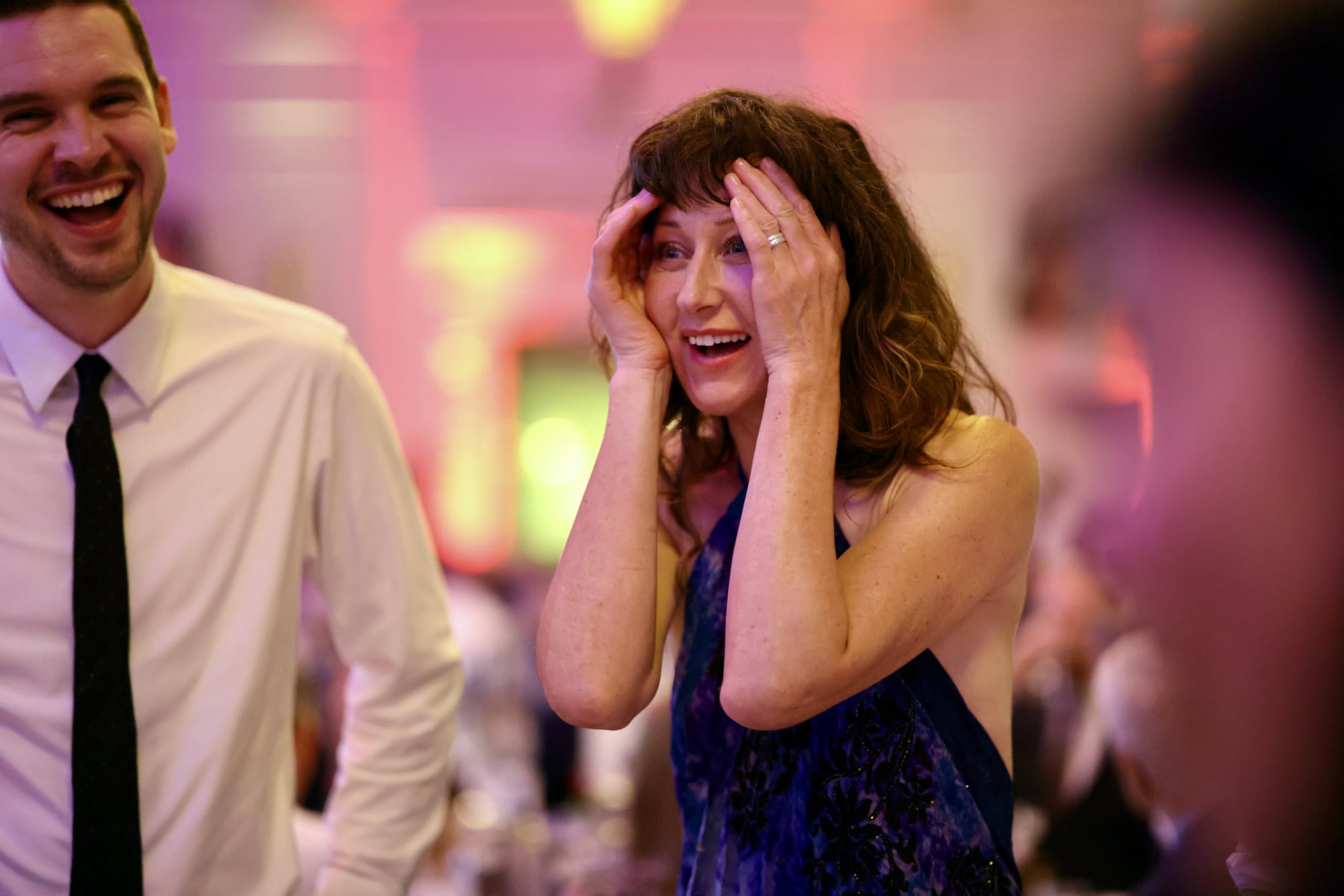 A guest amazed by a card trick at an awards dinner