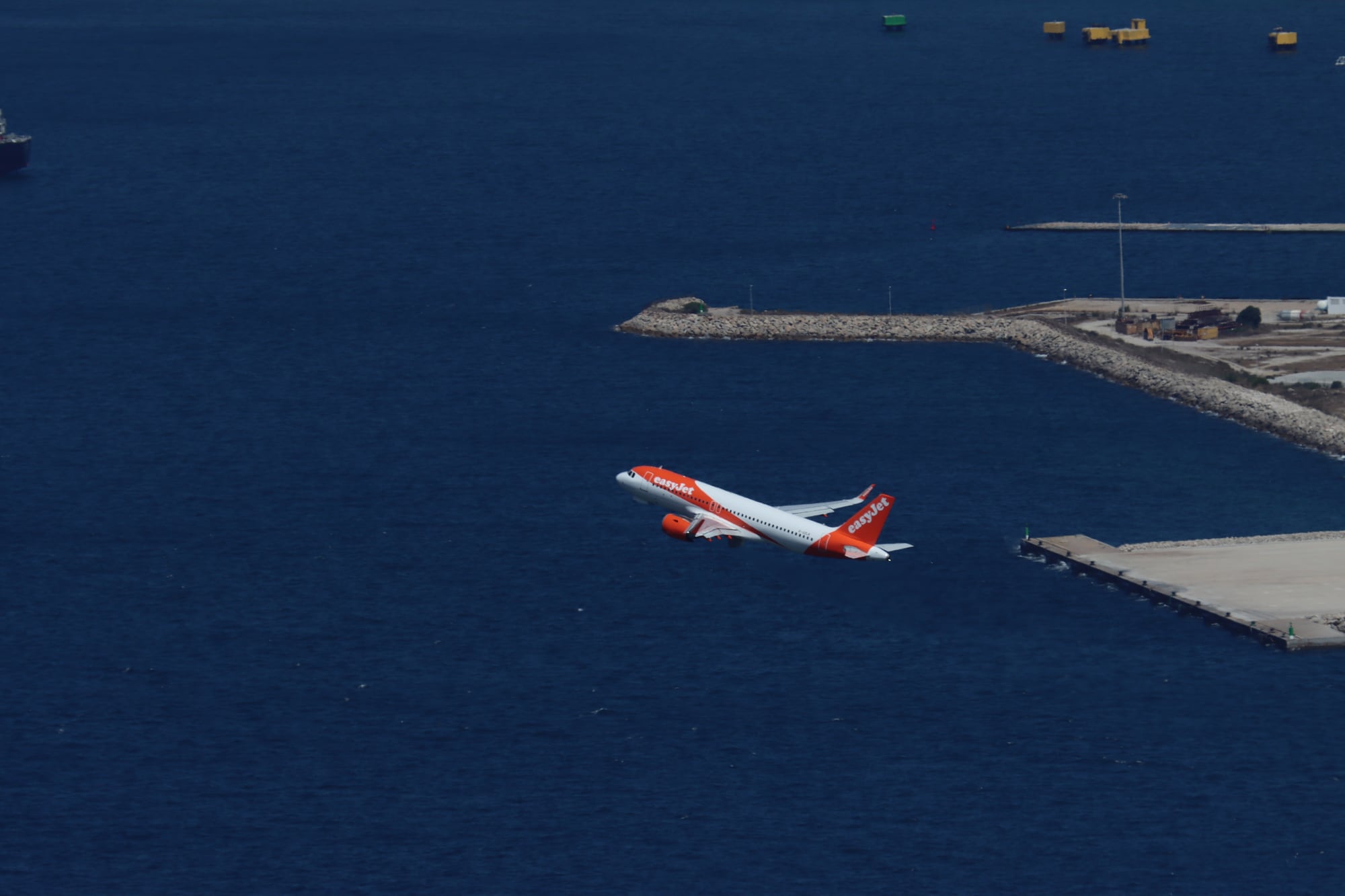 Five weeks on the Rock: A plane climbing out past the end of the runway