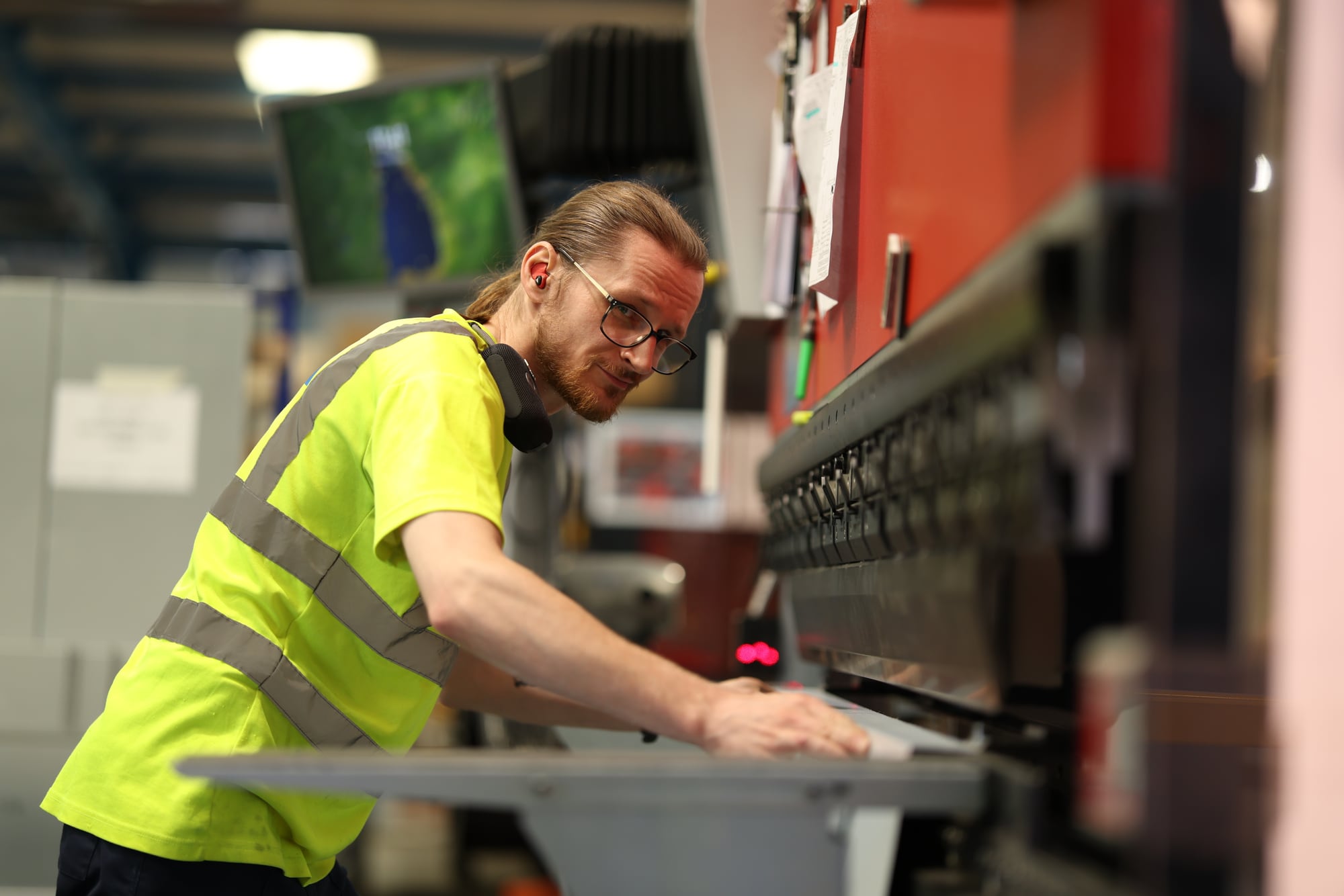 A press-brake operator at work in a factory