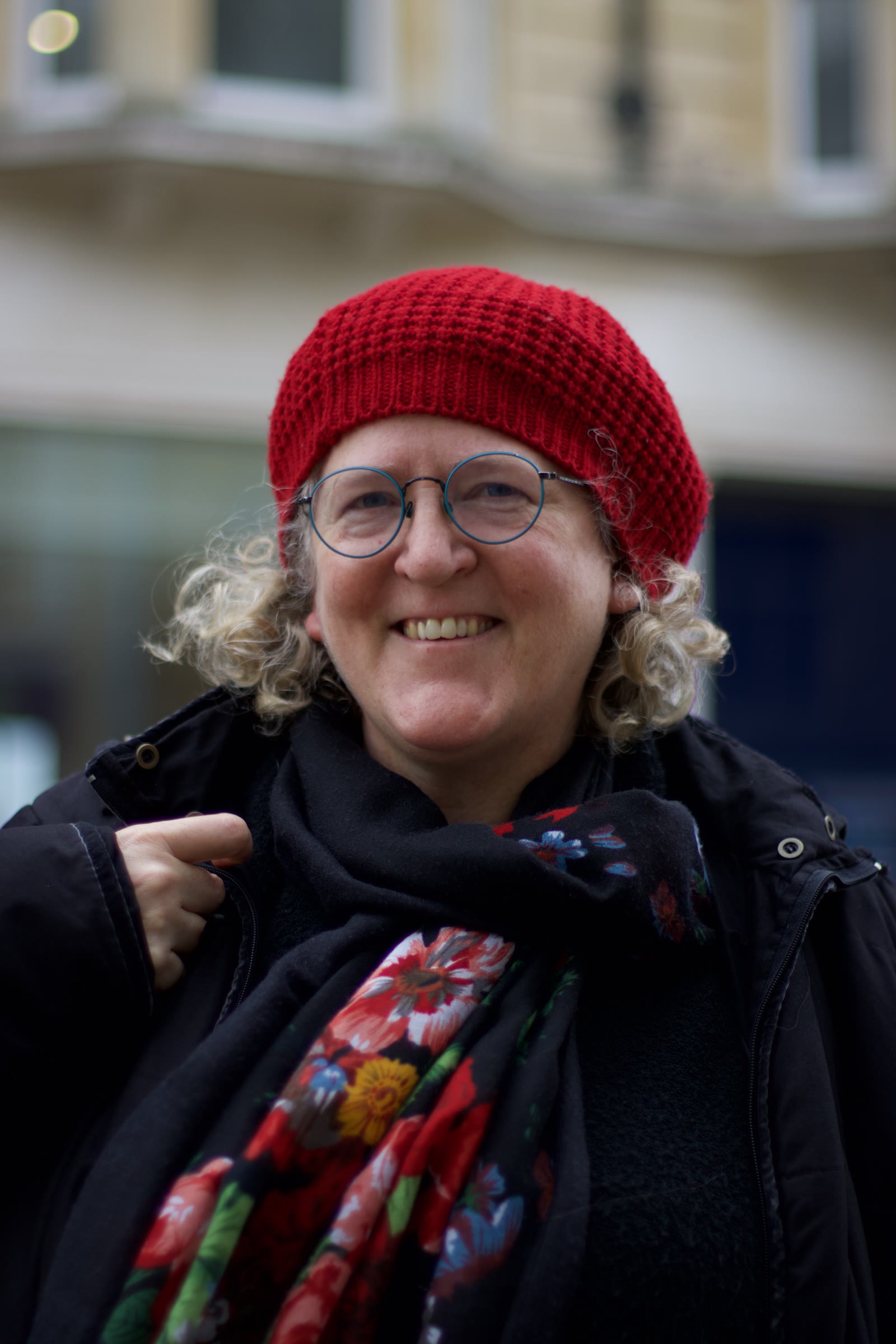 A street portrait in Oxford: an older woman in a red beret and round glasses