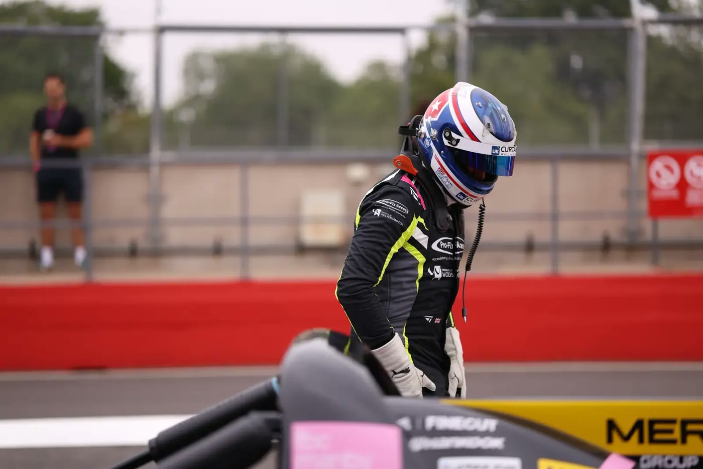 Pit lane: A driver climbing out in the pit lane