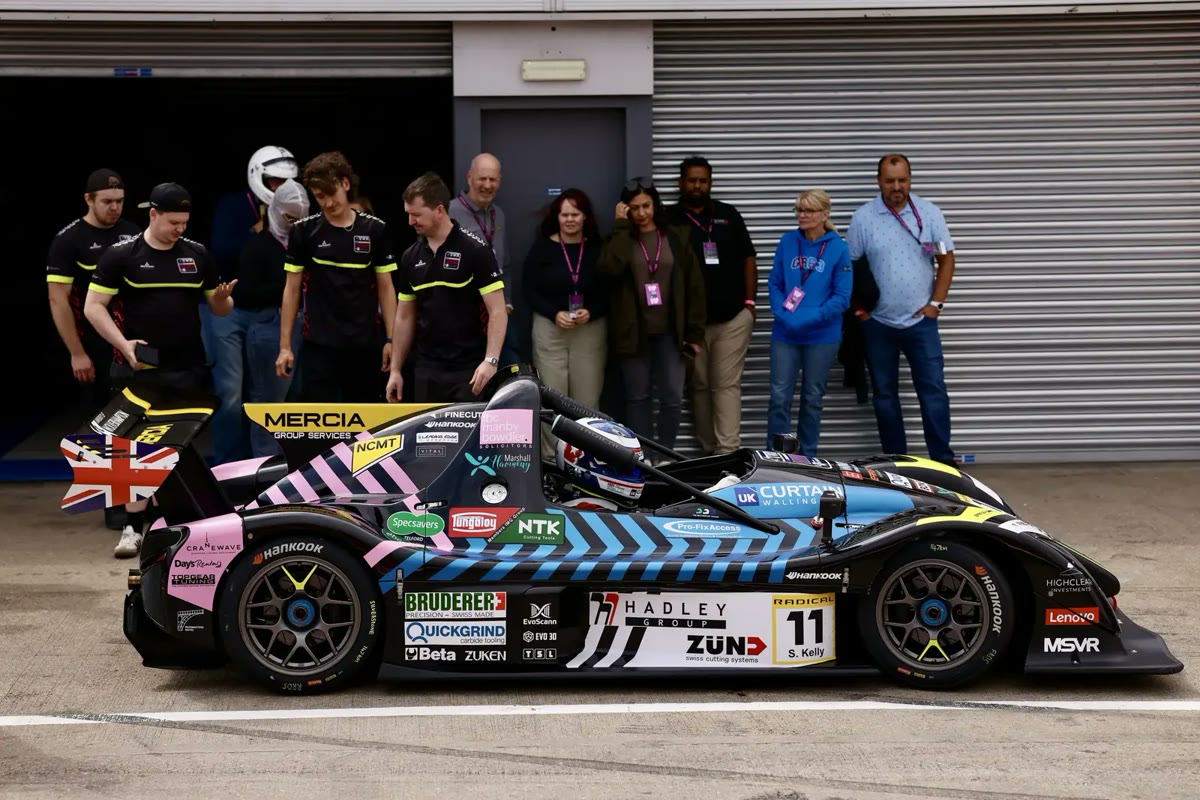 The team: The team and guests with the car in the pit garage